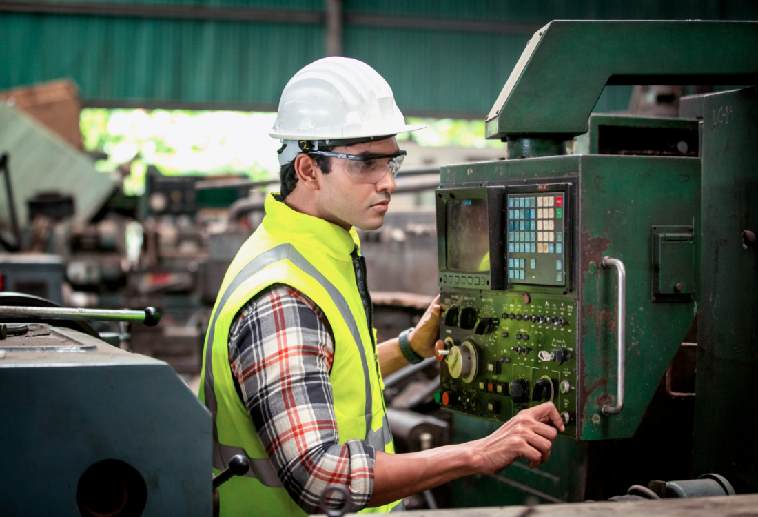 Factory worker operating operator friendly machinery in manufacturing industry.