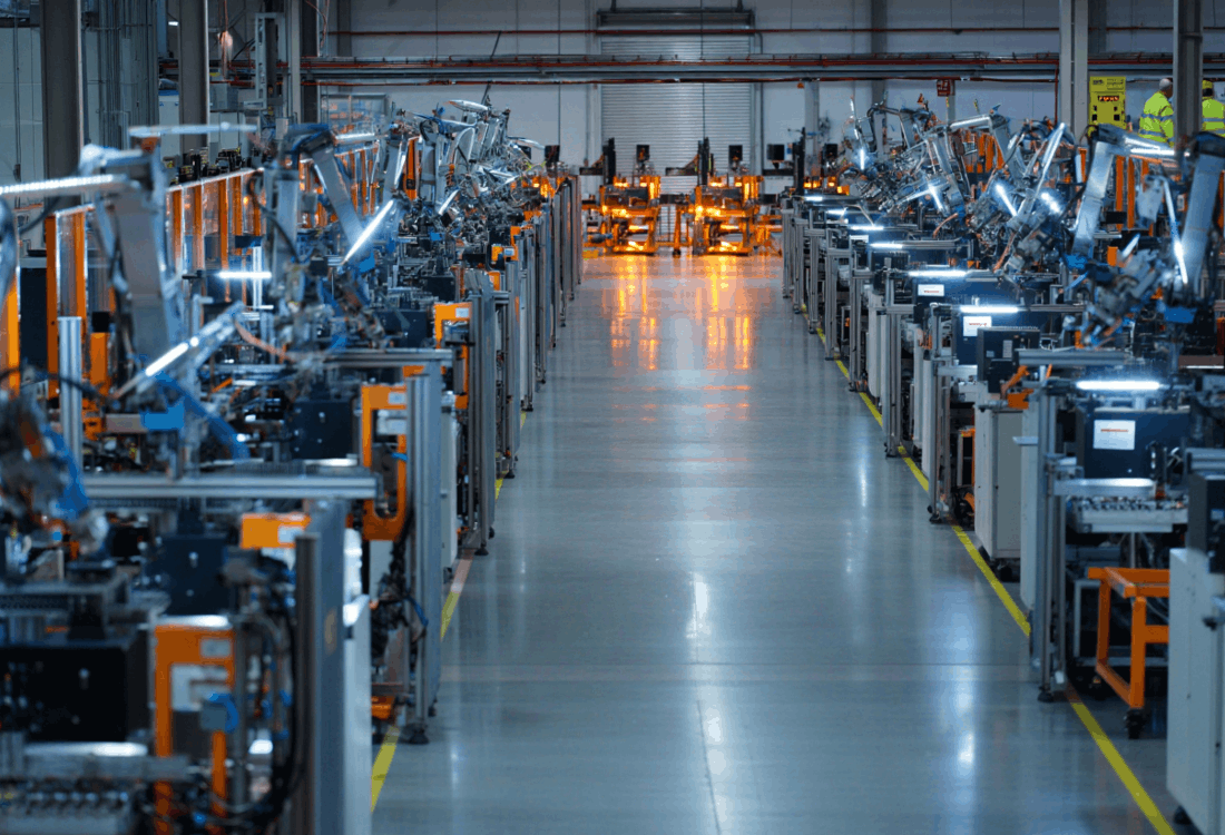 Automated production line with robotic arms operating in a smart factory, illustrating lights-out manufacturing where programme-saving features ensure consistent, repeatable quality without human intervention.