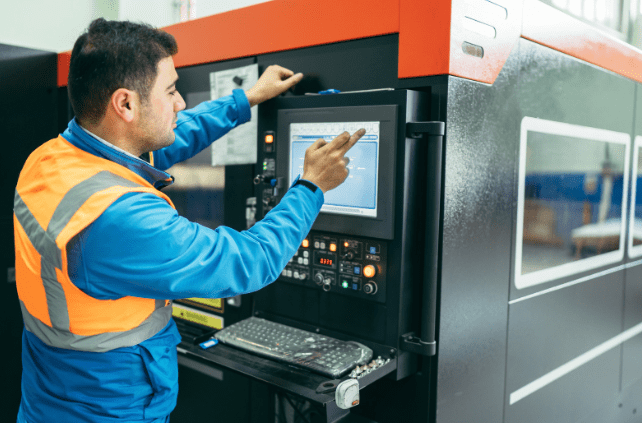 Factory worker operating an automated deburring machine via a touchscreen interface. The advanced system ensures precise burr removal, minimising rework and material waste while improving manufacturing efficiency.