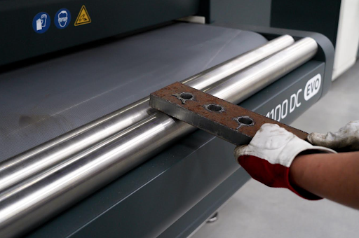 A worker safely removing rust and slag from a metal component using industrial slag removal equipment, enhancing metal quality and workplace safety.