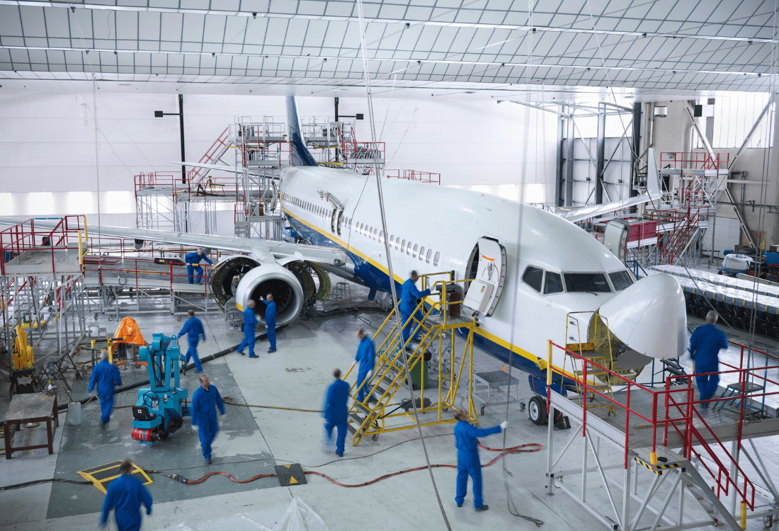 Engineers working on an aircraft in a maintenance hangar, checking for consistent edge quality which is crucial for aircraft performance, structural integrity, and compliance with industry standards. 