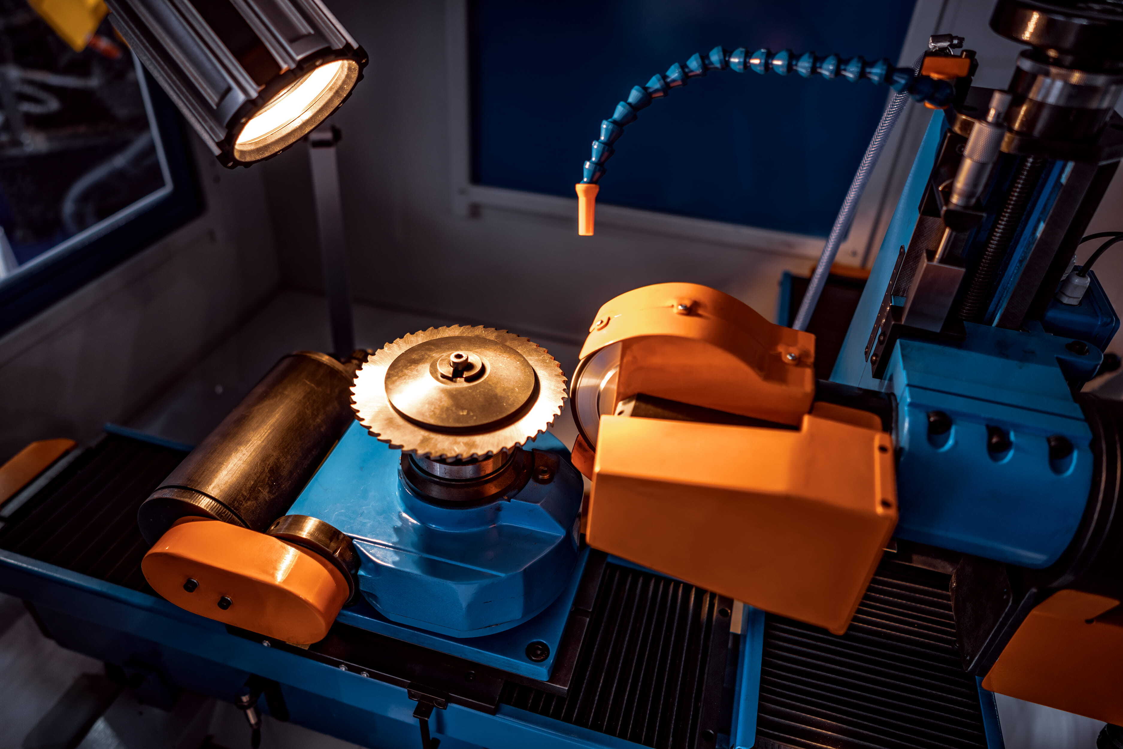 A used deburring machine with a rotating abrasive wheel, adjustable tooling, and task lighting in a workshop setting. 